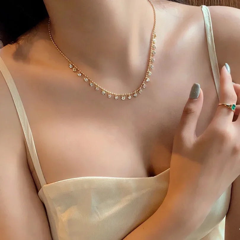 Close-up of a necklace on a person wearing a beige top.
