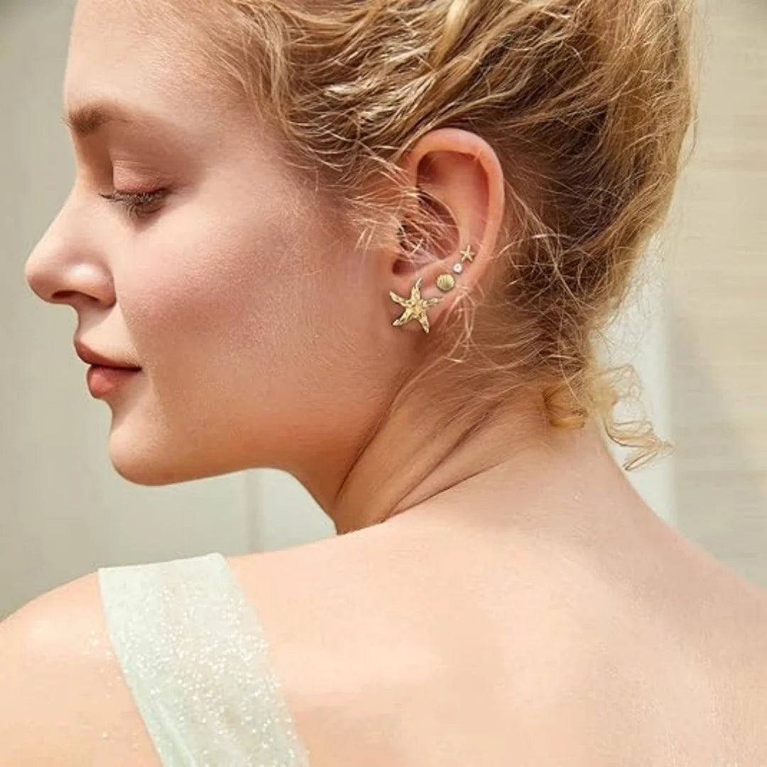 Close-up of a woman wearing a delicate earring with a neutral background