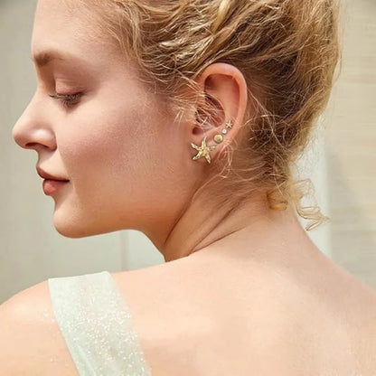 Close-up of a woman wearing a delicate earring with a neutral background