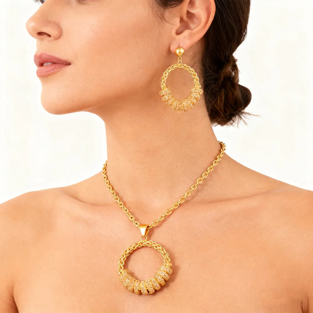 Gold hoop earrings and necklace on a model against a white background