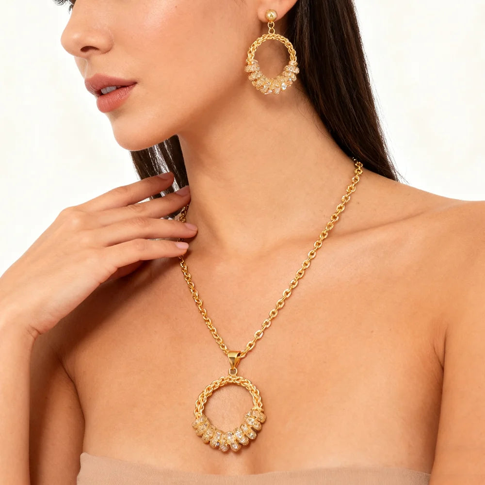 Woman wearing a gold necklace and earrings on a plain background