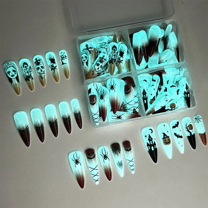 glow‑in‑the‑dark Halloween press‑on nails with skull and cross nail art — long almond shape.