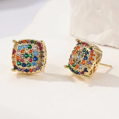 A pair of gold square stud earrings decorated with a colorful array of round-cut rhinestones in multiple hues, displayed on a clean white surface.