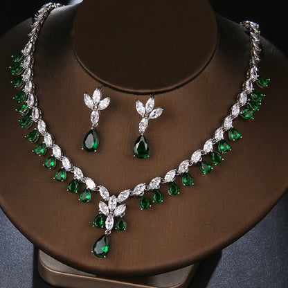 Green and silver jewelry set on a brown stand