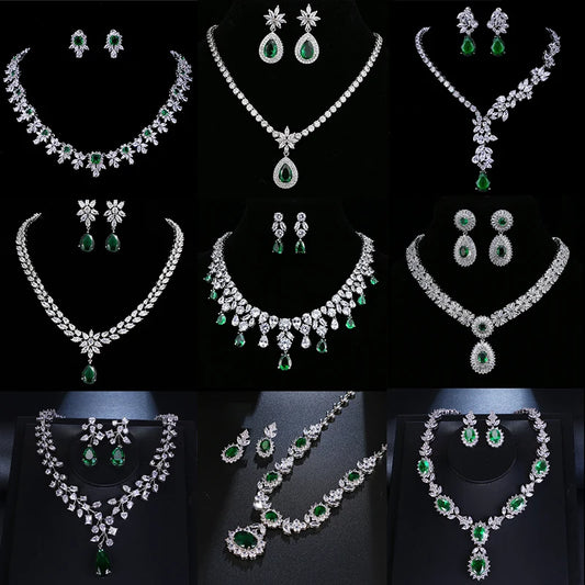 A collage showing eight different styles of women's jewelry sets, including necklaces, earrings, and rings, made of silver-toned metal with clear stones and green emerald-cut gemstones, displayed on black mannequins against a black background.