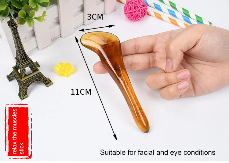 Hand holding a Gua Sha tool with measurements and text on a white background