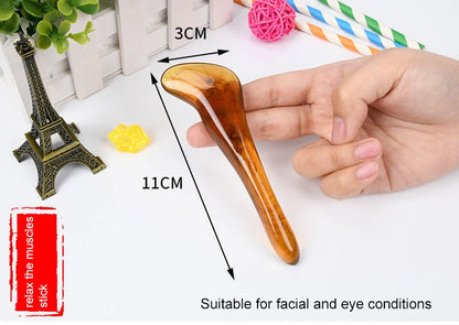 Hand holding a Gua Sha tool with measurements and text on a white background