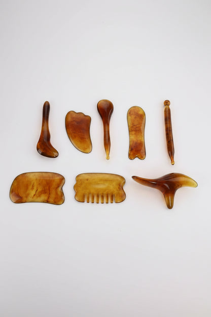 Beeswax scrape therapy set with various tools on a white background