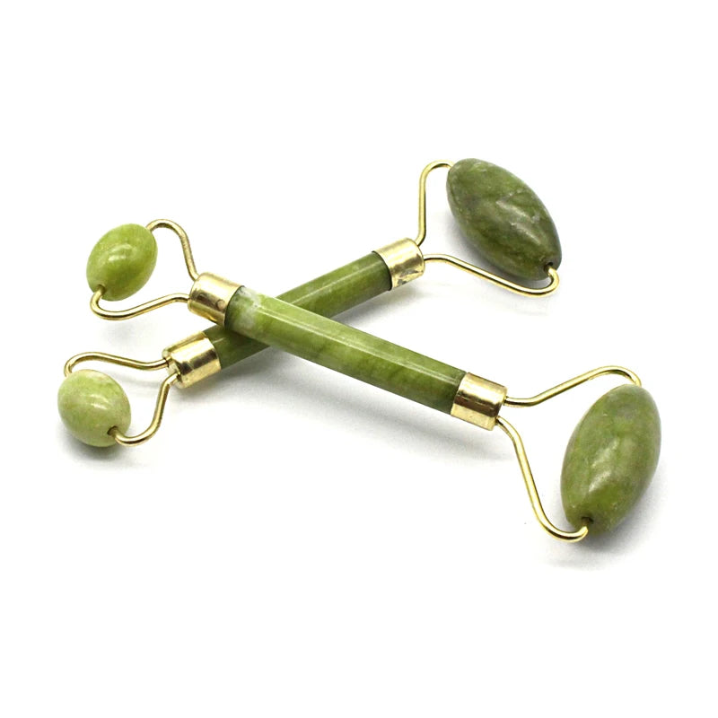 Green facial roller with gold accents on a white background
