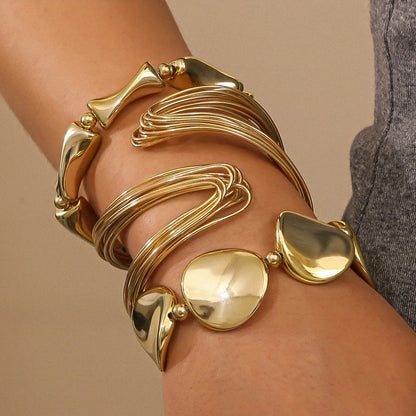 Gold bracelet on a wrist with a neutral background