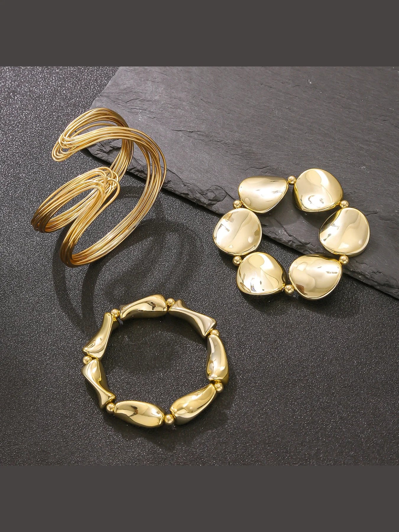 Three gold rings on a dark surface