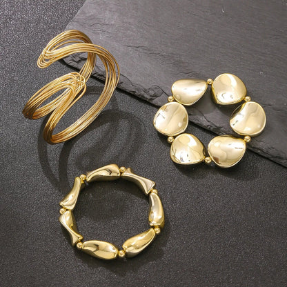 Three gold rings on a dark surface