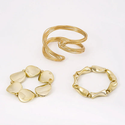 Three gold bracelets on a white background
