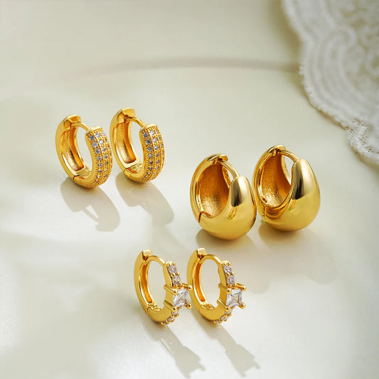 Set of gold hoop earrings on a light background