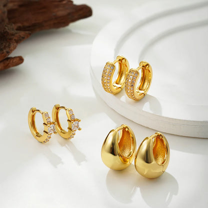 Gold hoop earrings with embedded stones on a white surface