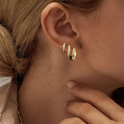 Close-up of an ear wearing gold hoop earrings