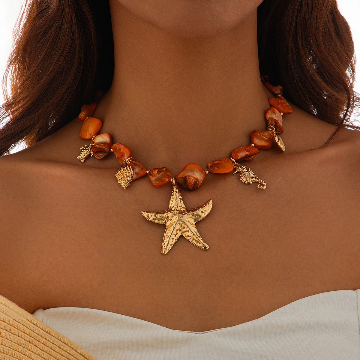 Necklace with starfish pendant and shell beads on a person against a neutral background