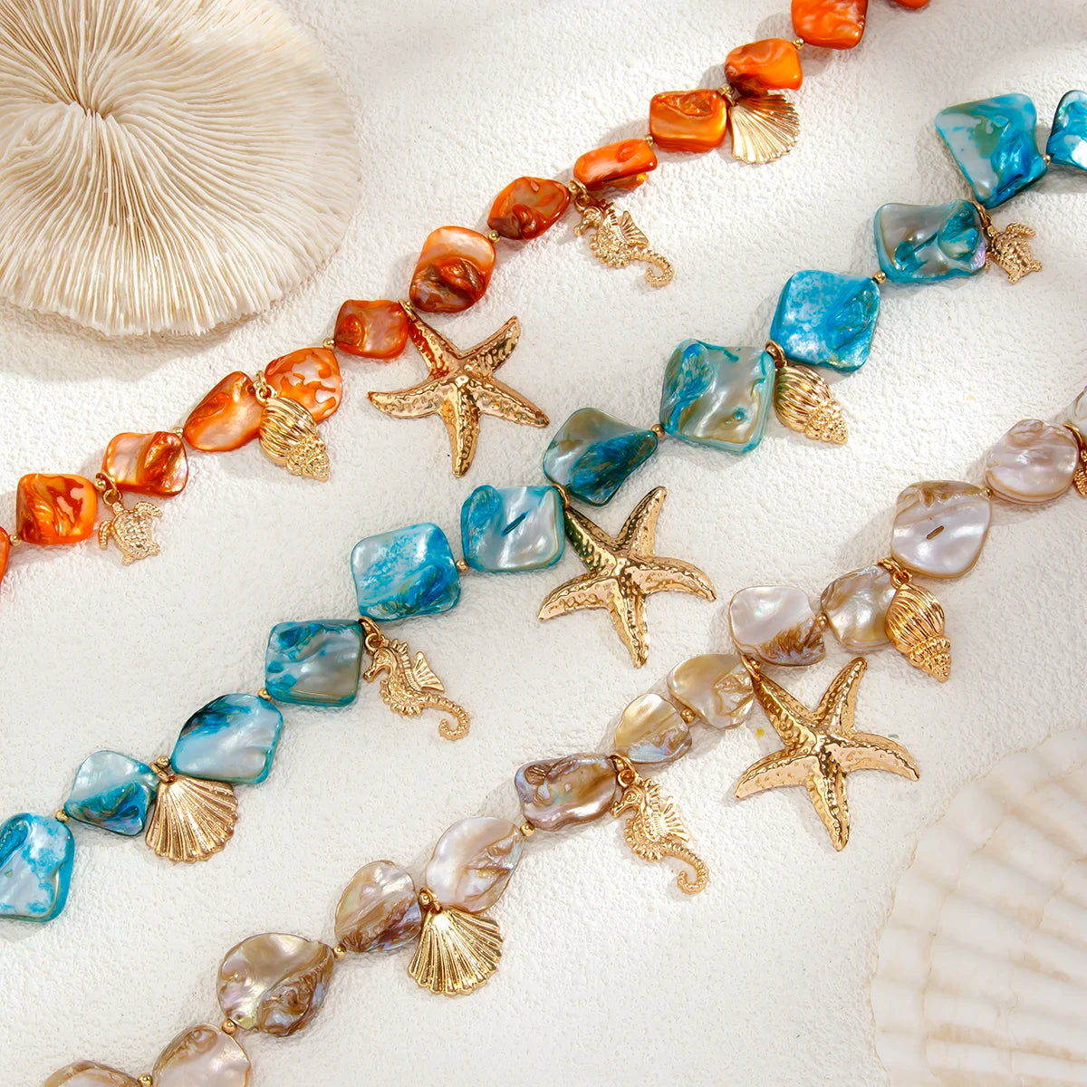 Necklace with starfish, shell, and coral elements on a sandy background