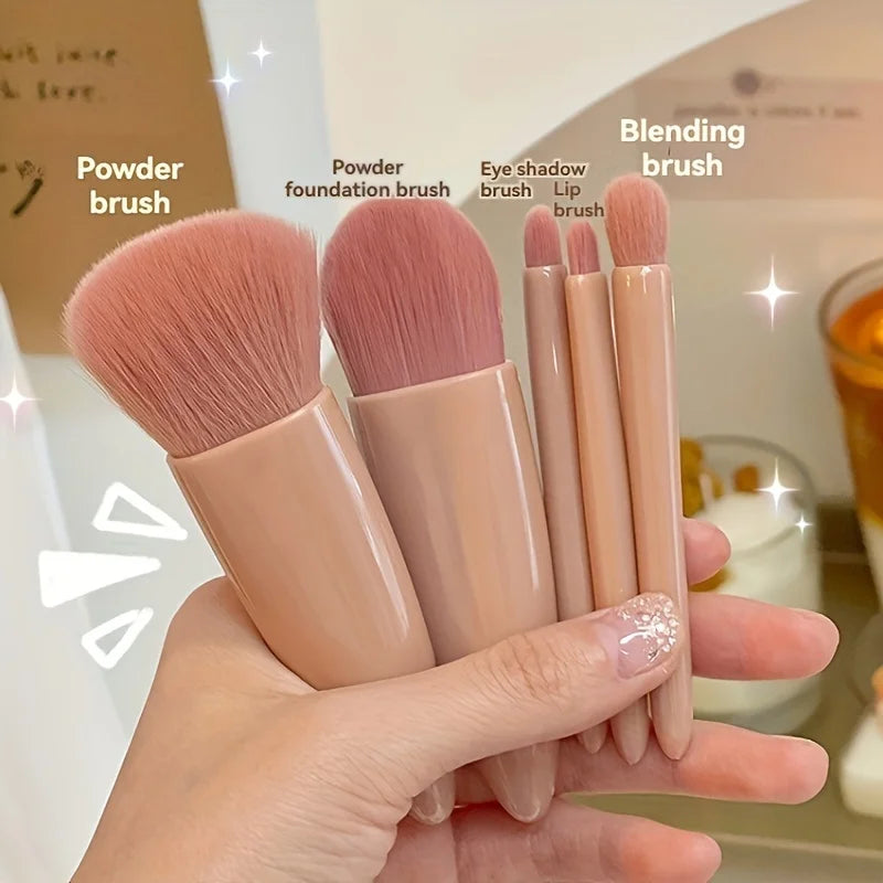 Set of makeup brushes held in a hand with labels on a blurred background