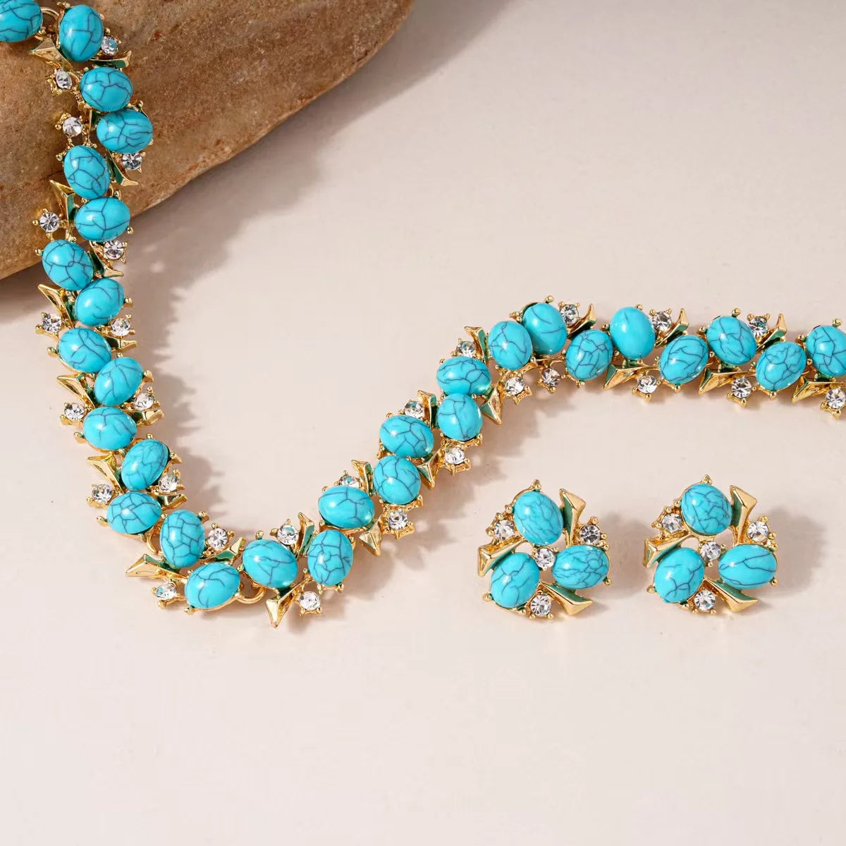 Turquoise jewelry set with necklace and earrings on a beige background