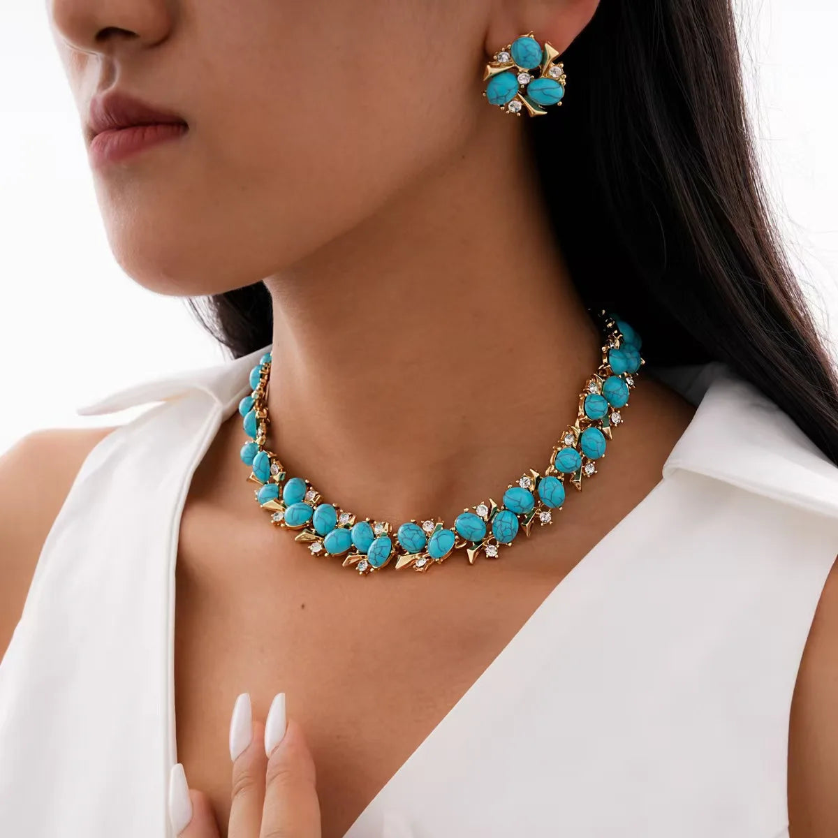 Turquoise jewelry set with necklace and earrings on a model wearing a white top.