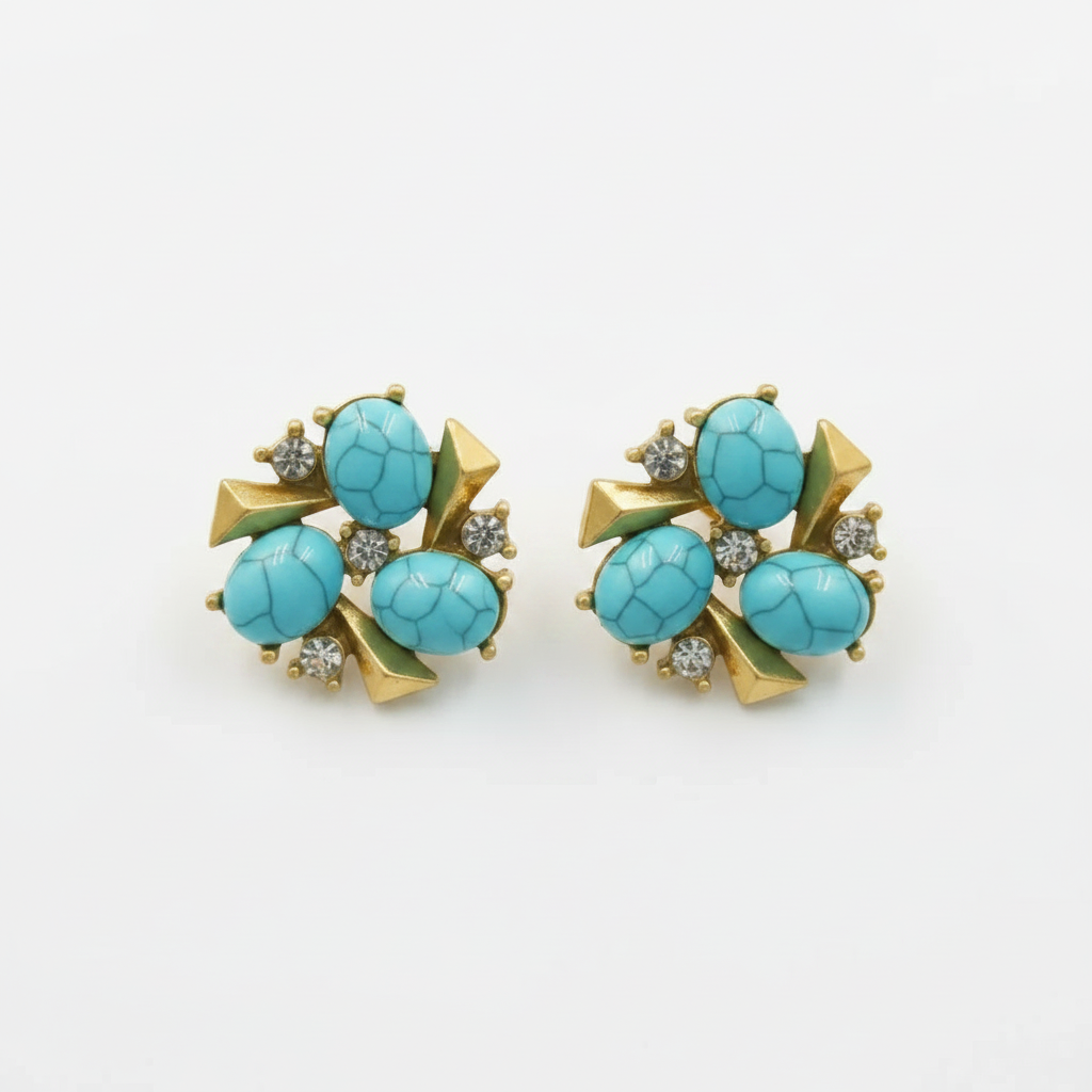 A pair of vintage gold-tone stud earrings featuring oval turquoise cabochons and small clear crystal accents, displayed on a neutral light gray background.