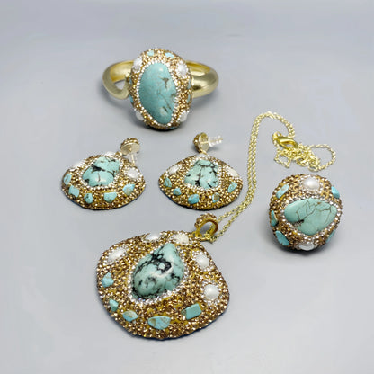 Jewelry set with turquoise stones and gold accents on a gray background