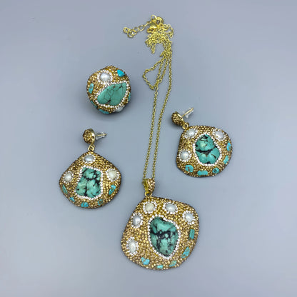Jewelry set with gold, turquoise, and pearl accents on a gray background